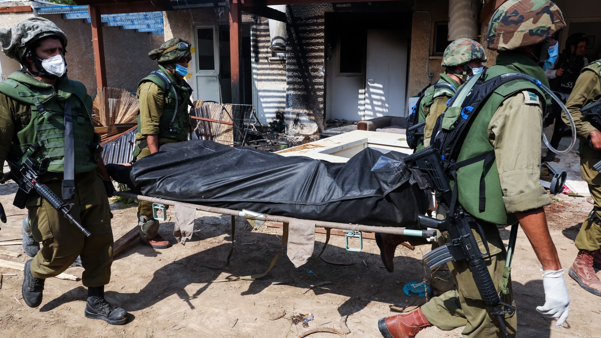 Israeli soldiers remove the body of a compatriot, killed during an attack by the Palestinian militants, in Kfar Aza, south of Israel bordering Gaza Strip, on October 10, 2023. 