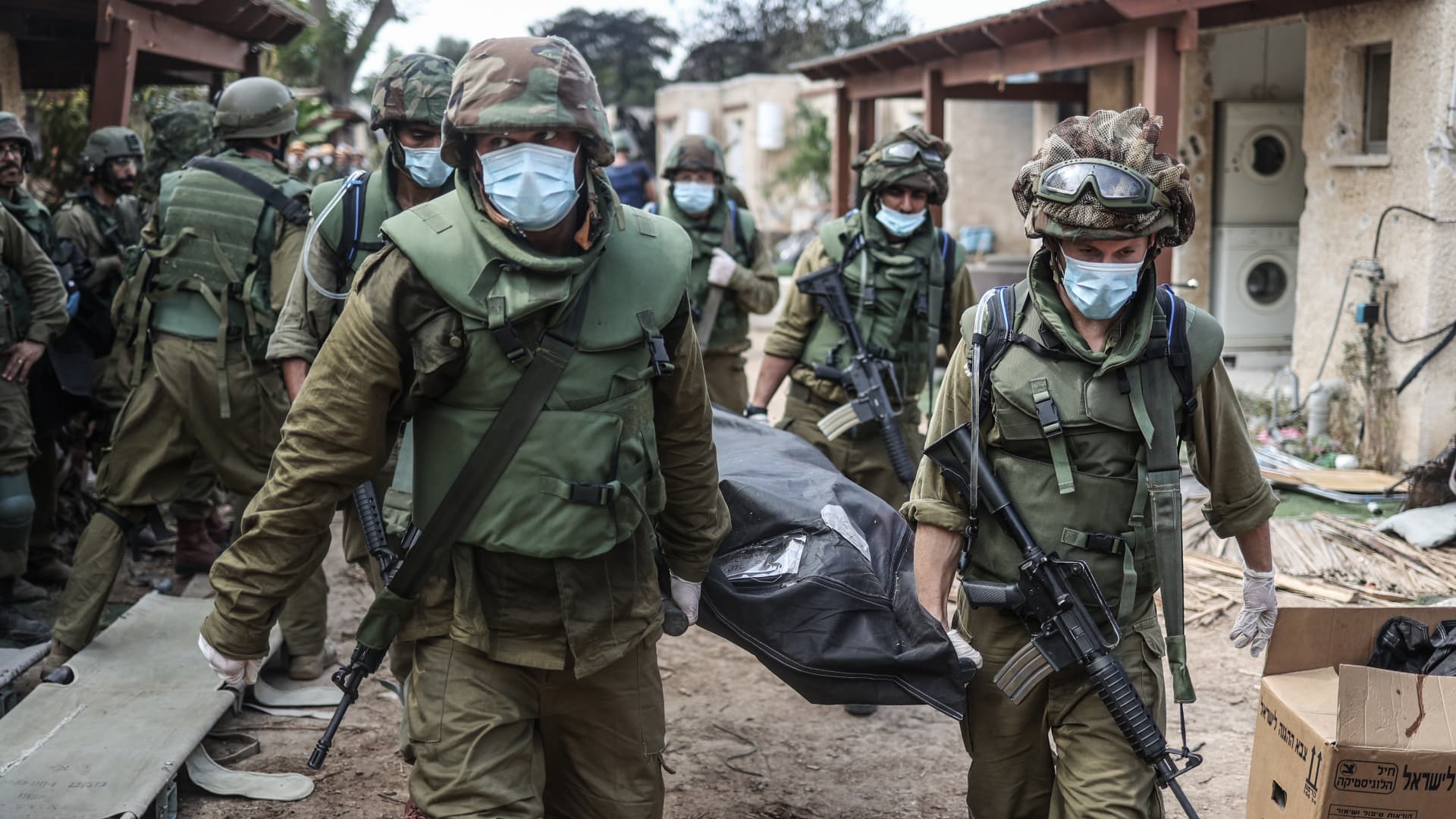 Israeli forces extracting dead bodies of Israeli residents from a destroyed house as fighting between Israeli troops and Hamas militants continues.