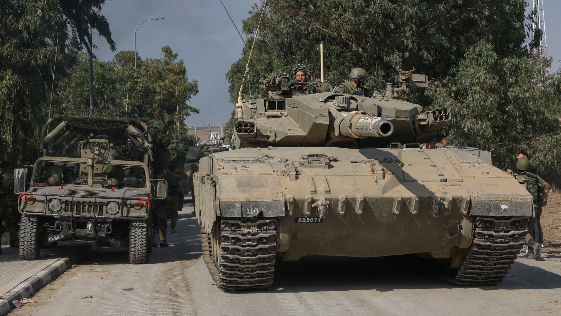 Israeli tanks leave the kibbutz of Kfar Aza in southern Israel after inspecting the area on the border with the Gaza Strip on Oct. 10, 2023.