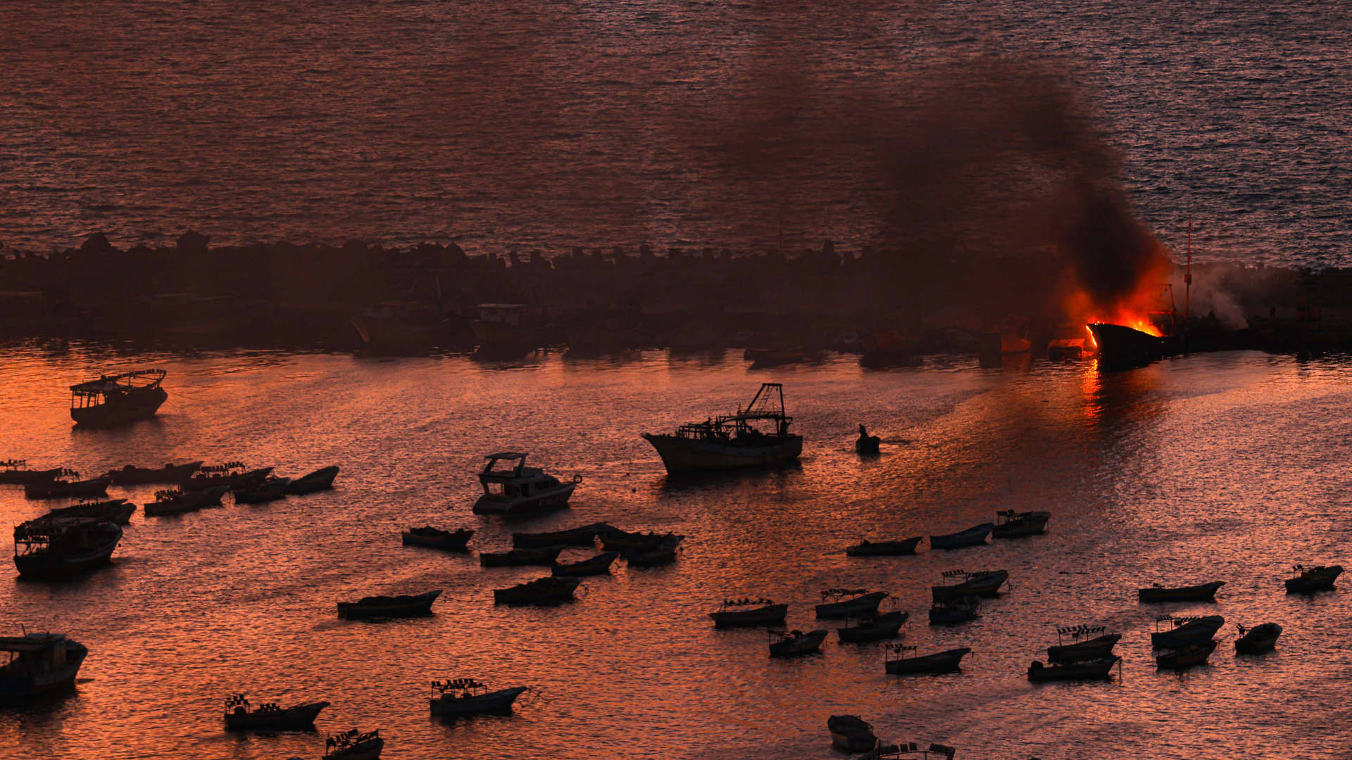 Smoke billows from a boat after a strike by Israel on the port of Gaza City on October 10, 2023. 