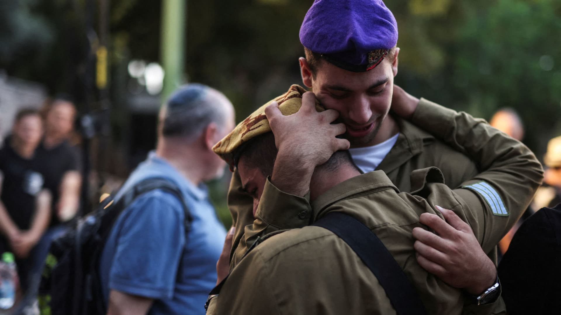 Israeli soldiers embrace as they mourn Ili Bar Sade, a soldier who was killed in an attack by Hamas militants, at his funeral in Tel Aviv, Israel, October 9, 2023.