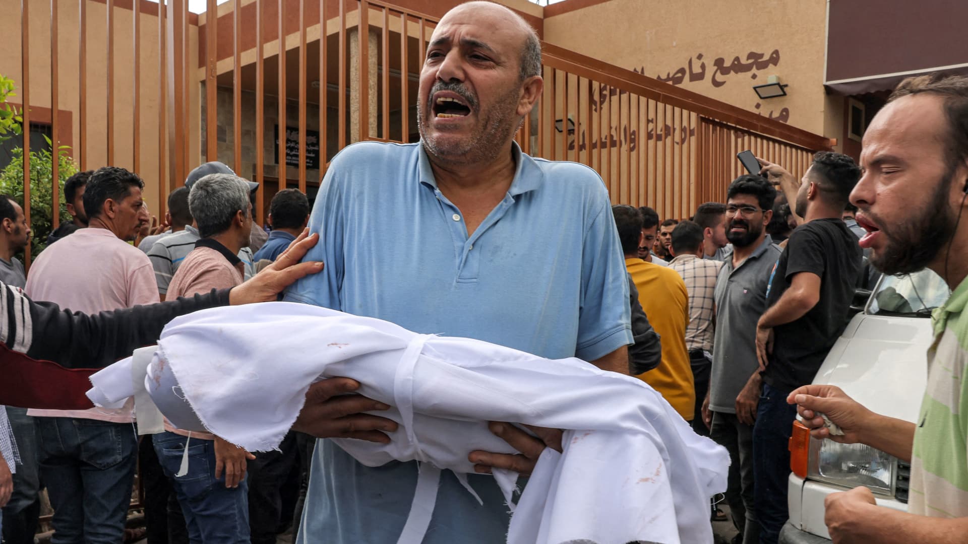 EDITORS NOTE: Graphic content / TOPSHOT - A man reacts while carrying the body of a Palestinian child killed in an Israeli air strike from a morgue for burial in Khan Yunis in the southern Gaza Strip on October 11, 2023. 
