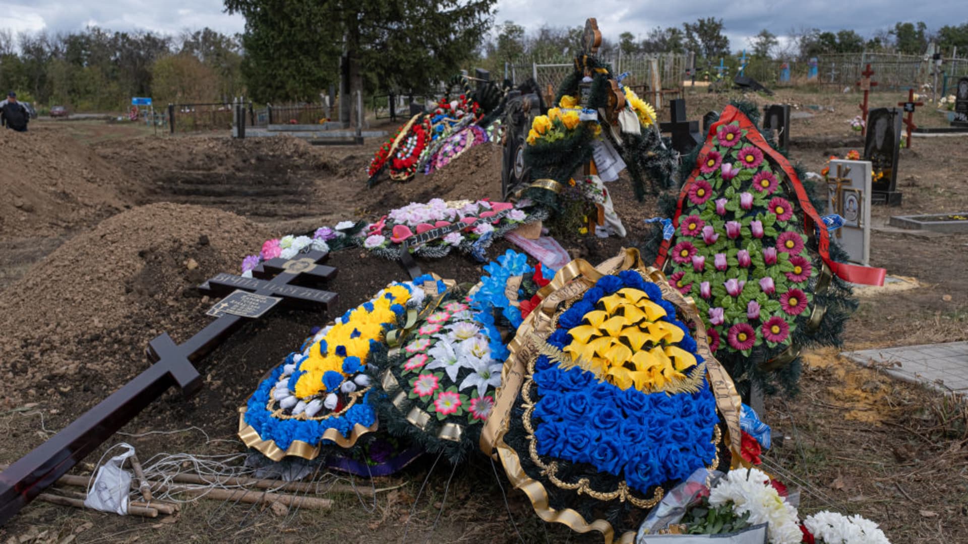 Crosses and flowers prepare to be placed on graves during funeral ceremony for victims of Russian rocket attack on small cafe as the war between Russia and Ukraine continues in Groza, Ukraine on October 10, 2023.