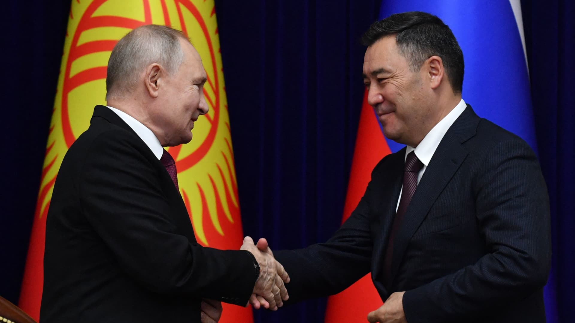 Russian President Vladimir Putin and his Kyrgyz counterpart Sadyr Japarov shake hands as they deliver a joint press statement following their talks in Bishkek on October 12, 2023.