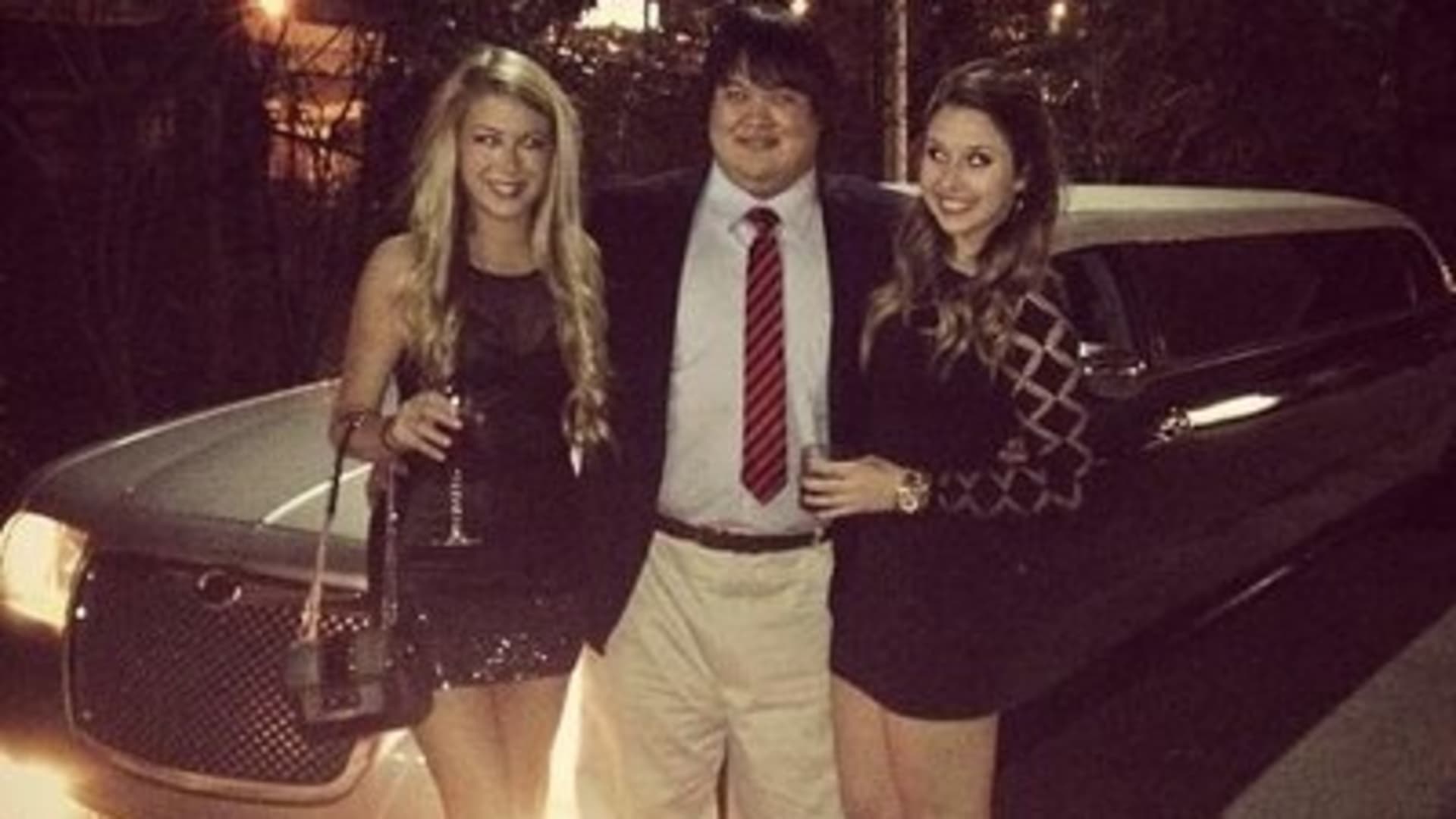 Zhong pictured with two women in front of a limousine.