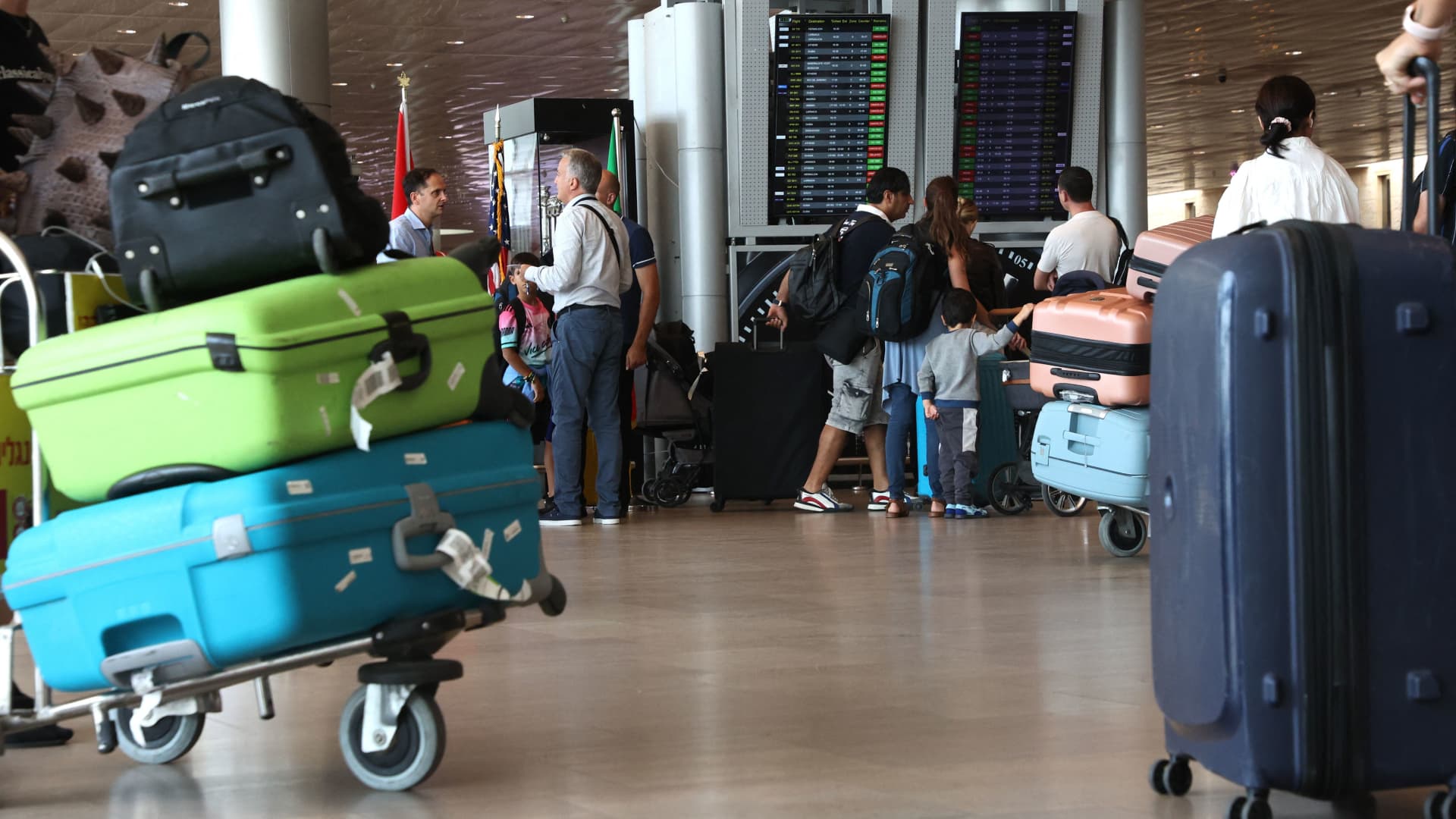 Travellers check the departure board at Ben Gurion International Airport near Tel Aviv on October 14, 2023, amid the ongoing battles between Israel and the Palestinian Islamist group Hamas. 