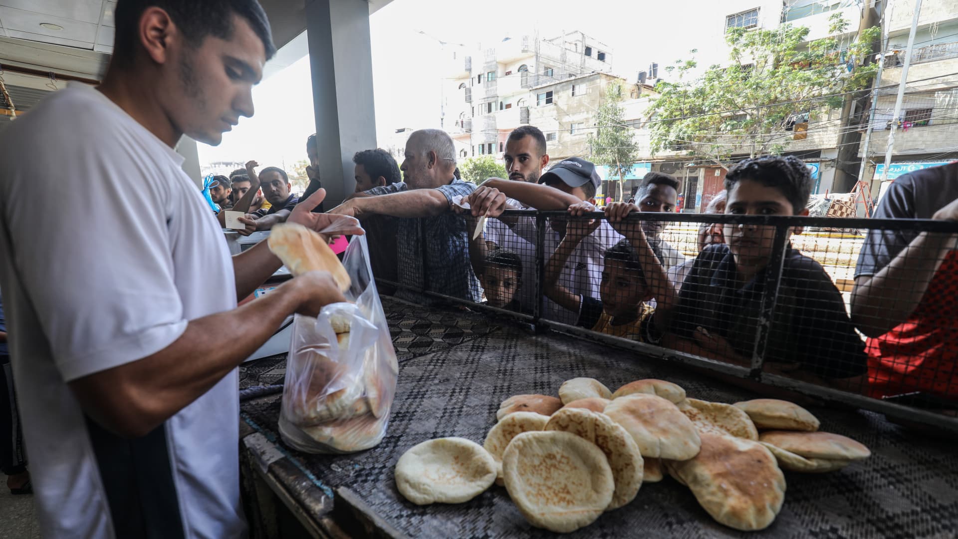 GAZA CITY, GAZA - OCTOBER 14: Palestinians line up in front of a bakery to buy bread as Israeli airstrikes continue on the 8th day in Gaza City, Gaza on October 14, 2023. Palestinians are trying to survive in an area without electricity, water, food and fuel. (Photo by Abed Rahim Khatib/Anadolu via Getty Images)