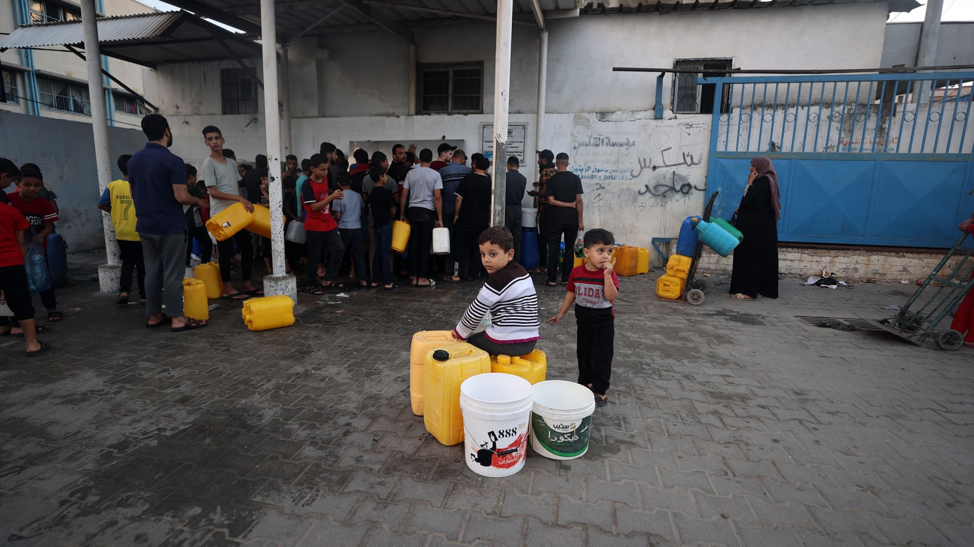 Palestinians fill water bottles and take them home as a UN report states that more than 2 million people struggle with water shortage, in Khan Younis, Gaza on October 14, 2023. 