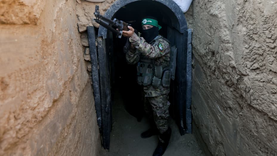 A fighter from Izz al-Din al-Qassam stands in front of a tunnel during an exhibition of weapons, missiles and heavy equipment for the military wing of Hamas in the Maghazi camp in the central Gaza Strip, during the commemoration of the 2014 war that lasted 51 days between Gaza and Israel.
