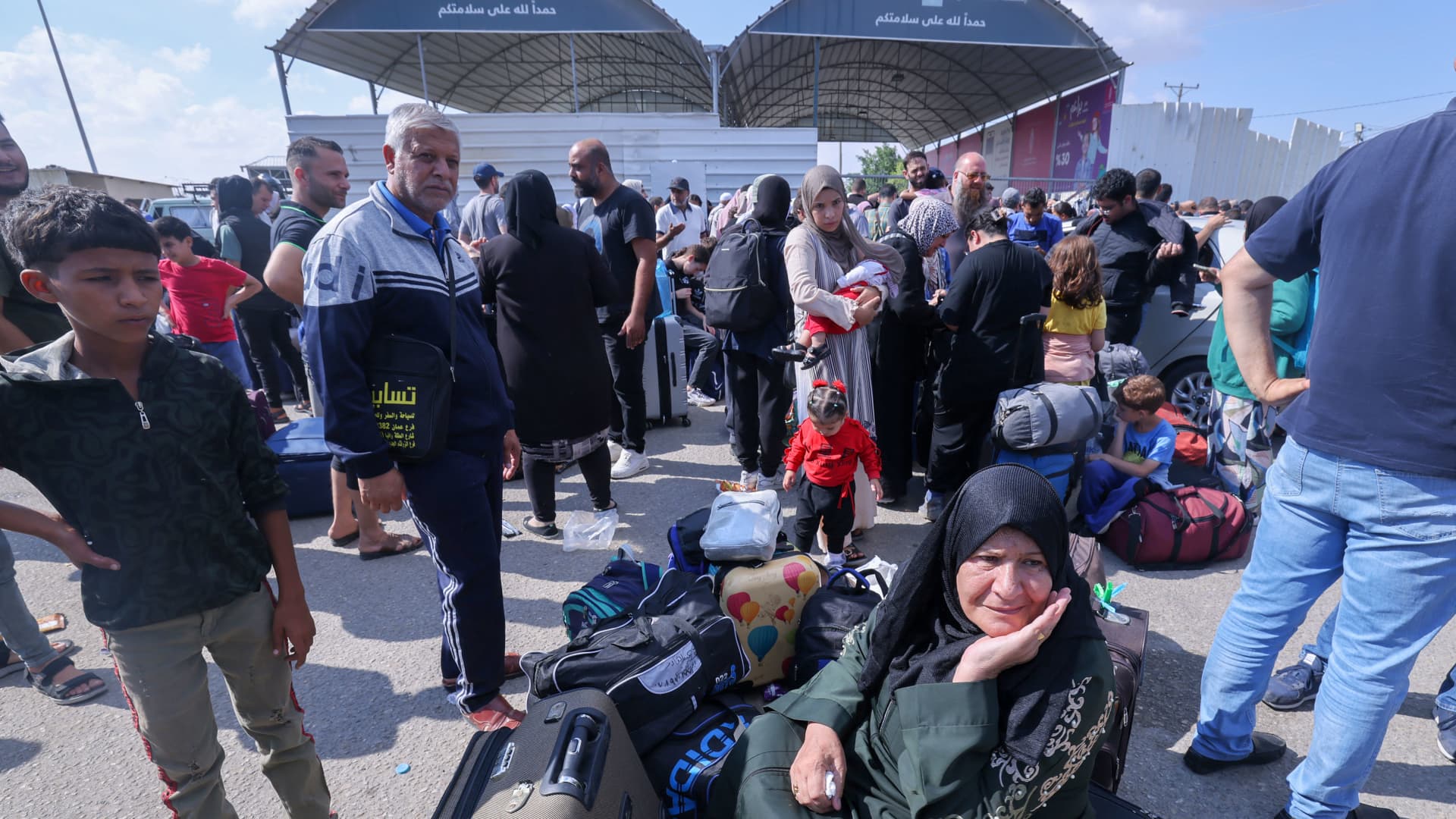 Palestinians, some with foreign passports hoping to cross into Egypt and others waiting for aid wait at the Rafah crossing in the southern Gaza strip, on October 16, 2023.
