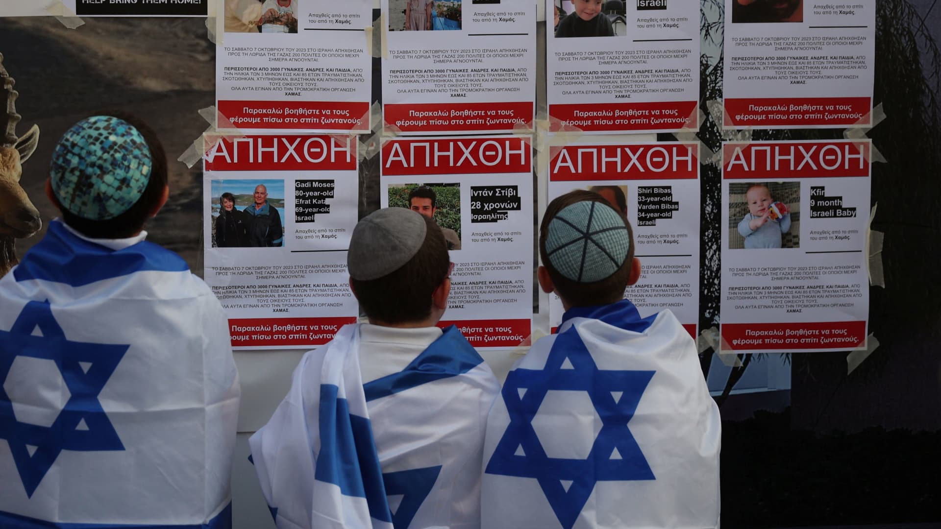 Young boys look at posters depicting missing people and stating that they were kidnapped by Hamas militants outside a Synagogue in Larnaca, Cyprus October 17, 2023.
