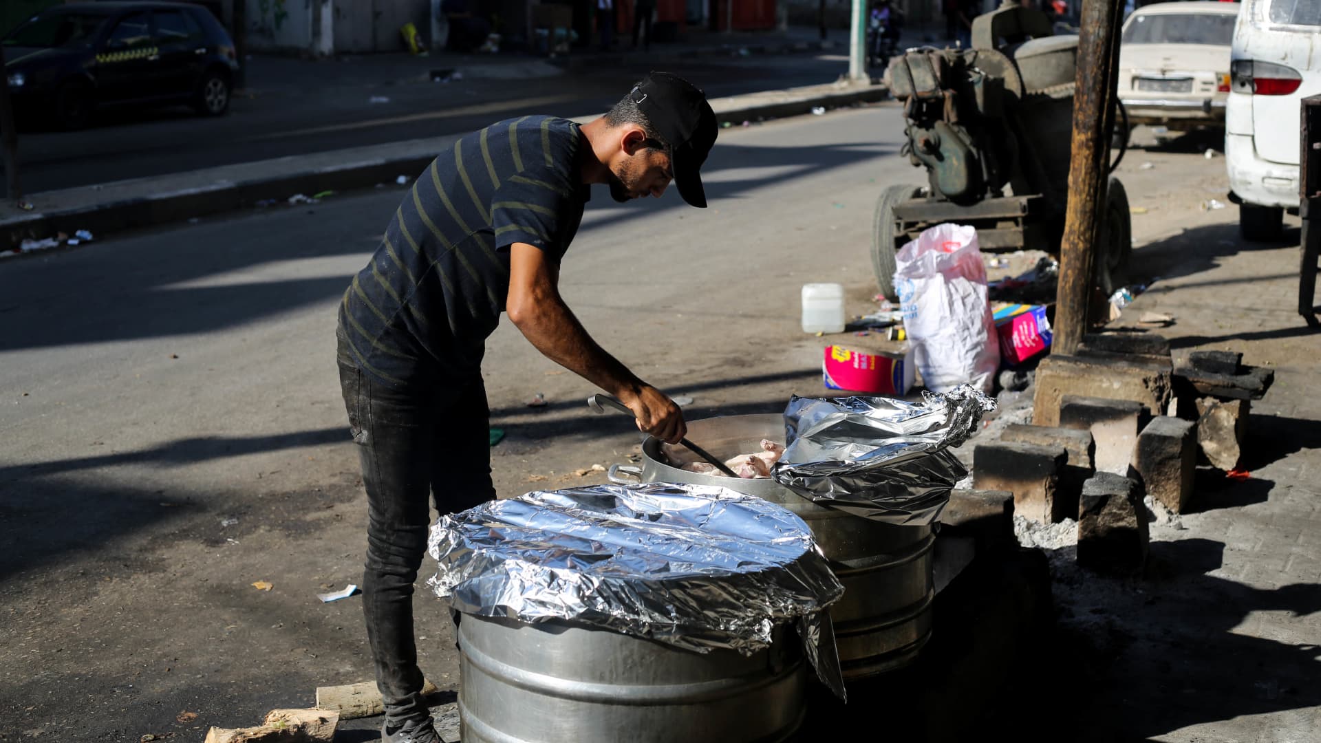 A Palestinian cook cooks and prepares food for displaced people whose homes were destroyed during Israeli raids on the southern Gaza Strip on October 18, 2023 in Khan Yunis, Gaza.