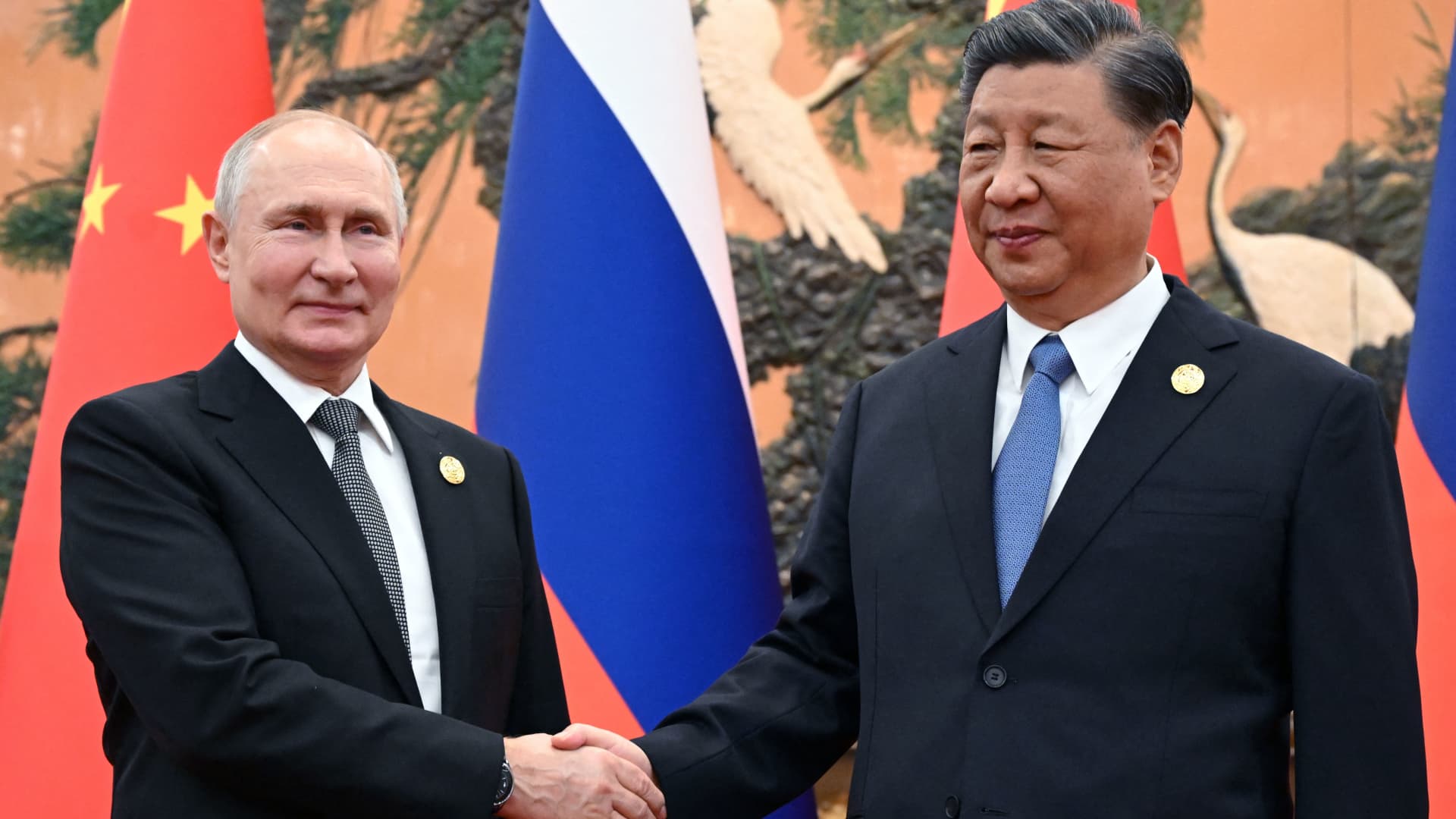 This pool photograph distributed by Russian state owned agency Sputnik shows Russia's President Vladimir Putin and Chinese President Xi Jinping shaking hands during a meeting in Beijing on October 18, 2023. 