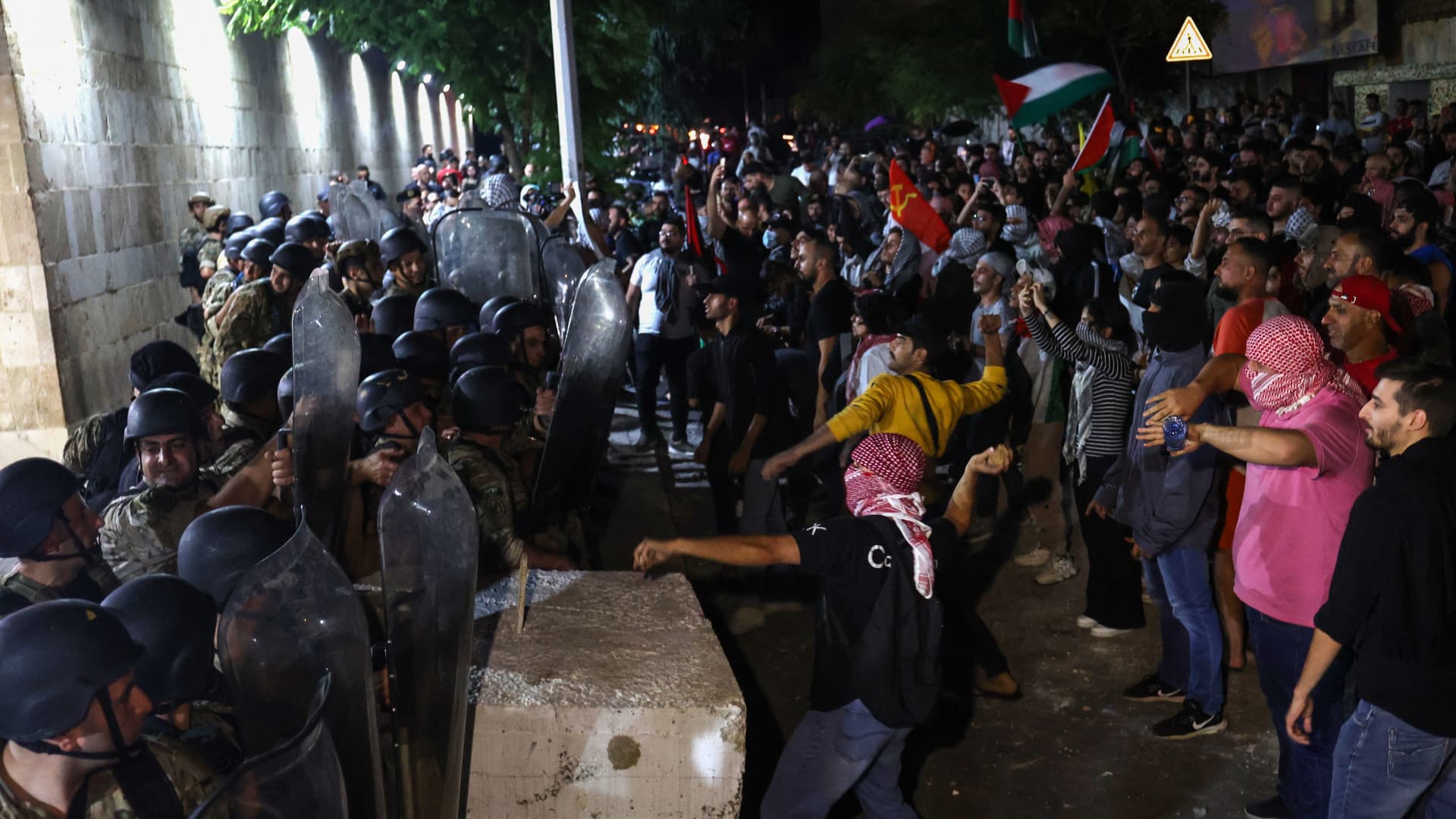 Members of the Lebanese army and police stand guard as protesters hurl rocks at the entrance of the French embassy complex in Beirut early on October 18, 2023, during a rally in support of Palestinians after a strike on the Ahli Arab hospital in central Gaza that killed hundreds.
