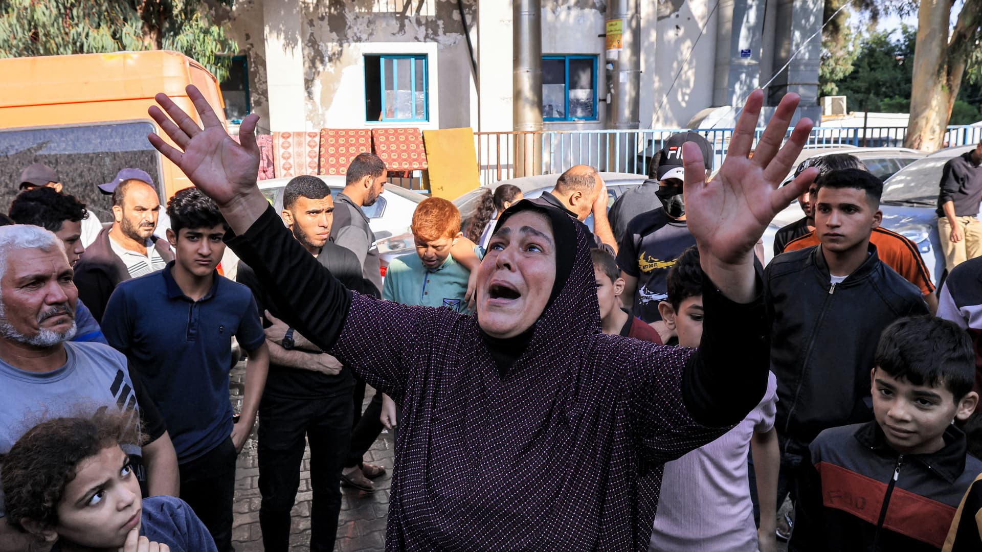 A woman reacts as people gather at the site of the Ahli Arab hospital in central Gaza on October 18, 2023 in the aftermath of an overnight strike there. 
