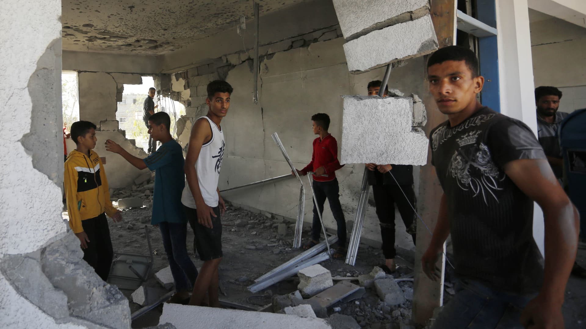 Men and children check the damage inside a UN-run school in the refugee camp of Al-Maghazi in the central Gaza Strip, a day after at least 6 people were killed in a reported Israeli strike, on October 18, 2023. 