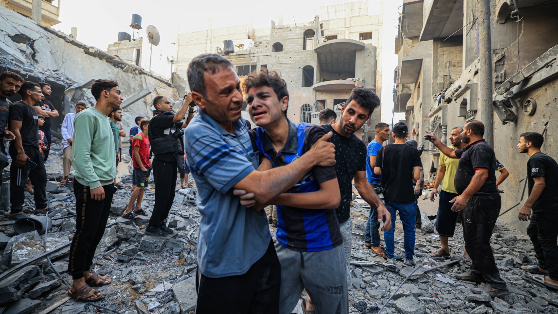 Palestinian civil defence members and others carry a youth after being rescued from a building hit by Israeli bombardment in Khan Yunis on the southern Gaza Strip on October 19, 2023. 