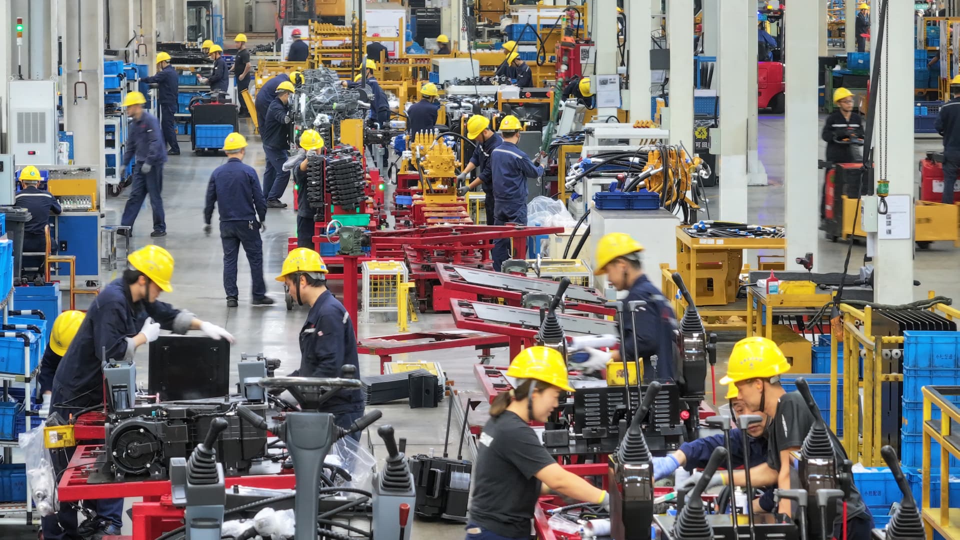 Des ouvriers assemblent des mini-pelles dans une usine de machinerie lourde à Suzhou, dans la province du Jiangsu (est de la Chine), le 23 octobre 2023.