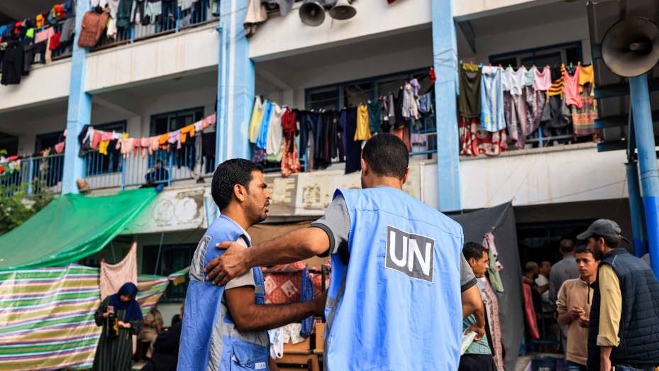 Workers of the United Nations Relief and Works Agency for Palestine Refugees (UNRWA) agency in the playground of an UNRWA-run school that has been converted into a shelter for displaced Palestinian people.