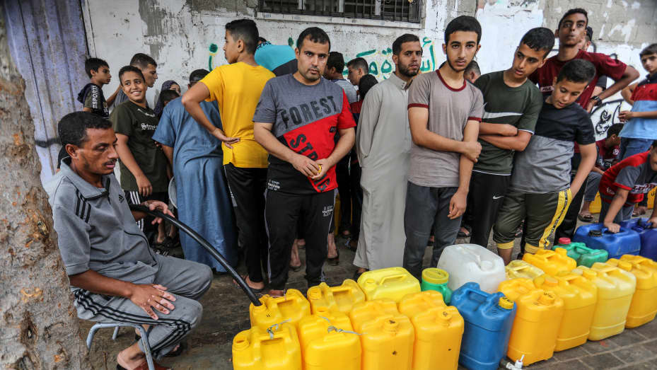 RAFAH, GAZA - OCTOBER 28: People line up in front of a water tank with their bottles due to water crisis as a result of the suspension of water flow in the water pipes from Israel to the Gaza Strip in Rafah, Gaza on October 28, 2023. (Photo by Abed Rahim Khatib/Anadolu via Getty Images)