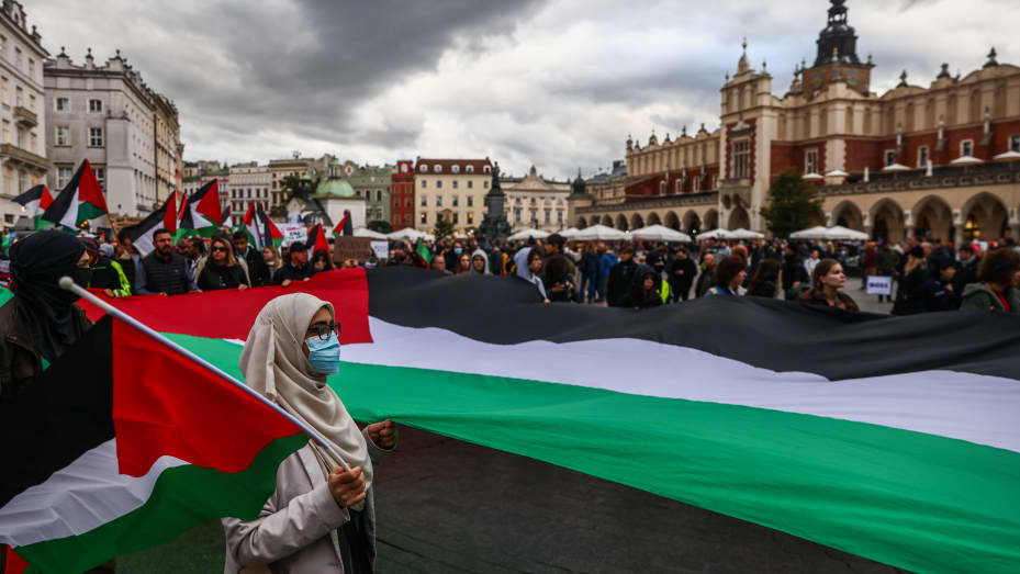 Members of Palestinian diaspora and supporters hold huge flag during solidarity with Palestine demonstration at the Main Square in Krakow, Poland on October 28, 2023.