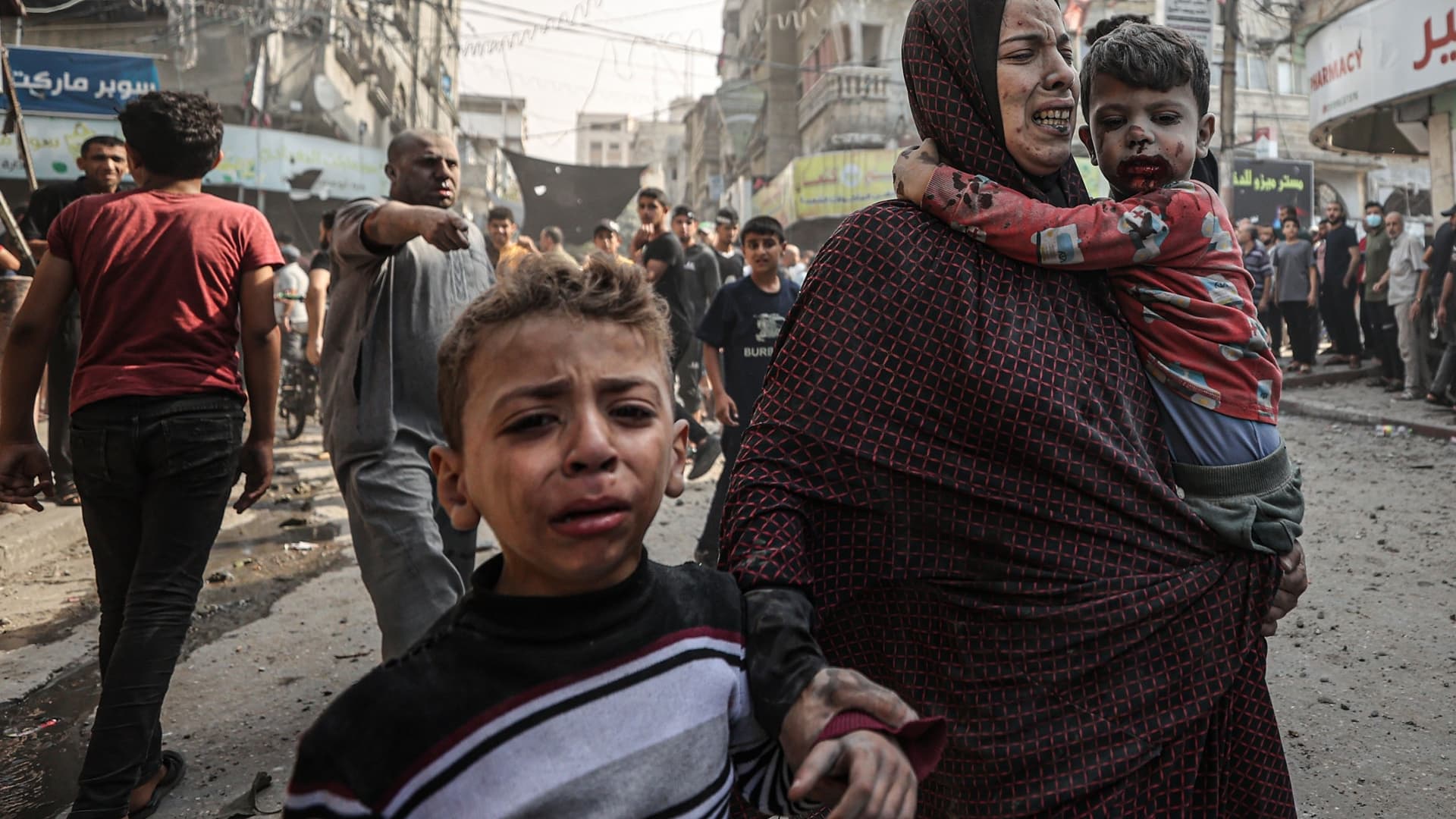 (EDITORS NOTE: Image depicts graphic content) A woman and children, all injured, try to get to the safety amid destruction and chaos caused by Israeli airstrikes on Bureij refugee camp in central Gaza Strip on November 02, 2023. (Photo by Mustafa Hassona/Anadolu via Getty Images)