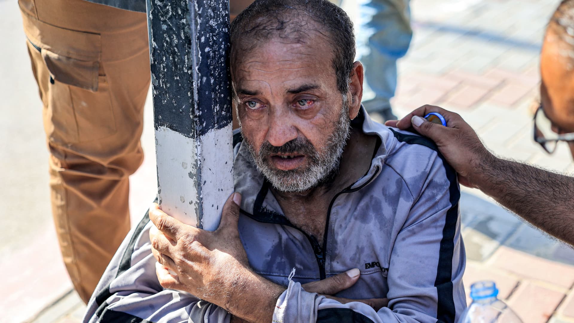 One of the Palestinian workers who were stranded in Israel since the October 7 attacks is assisted after he collapsed upon arriving at the Rafah border crossing with Egypt after crossing into the Gaza Strip at the Kerem Shalom commercial border crossing with Israel in the south of the Palestinian enclave on November 3, 2023.