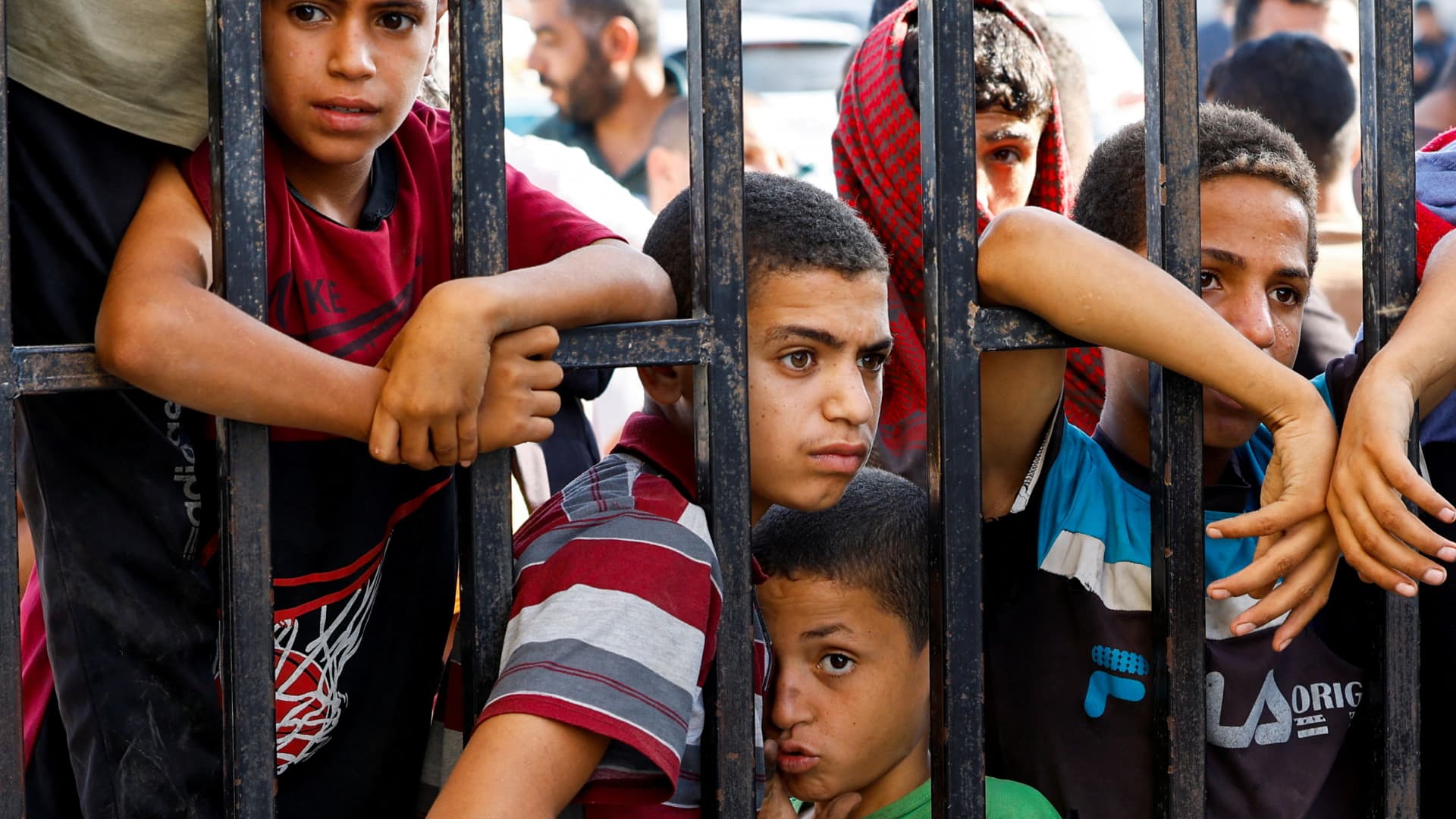 Children wait for the arrival of Palestinian workers, who were in Israel during the Hamas October 7 attack, at the Rafah border after being sent back by Israel to the strip, in the southern Gaza Strip, November 3, 2023.