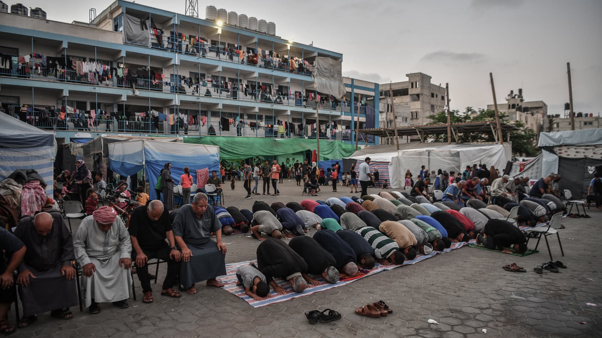 Palestinians perform an evening prayer on a backyard of a school, affiliated to United Nations Relief and Works Agency (UNRWA), as the Israeli attacks continues in Khan Younis, Gaza on November 2, 2023.