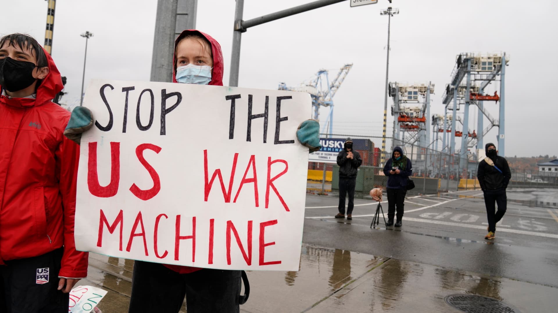 Stop The US War Machine sign held as protesters block access to an entry point at the Port of Tacoma in Tacoma, Washington, US, on Monday, Nov. 6, 2023. The protesters are demonstrating what they believe is a military supply ship that is docked at the port and bound for Israel, according to the Seattle Times. Photographer: M. Scott Brauer/Bloomberg via Getty Images