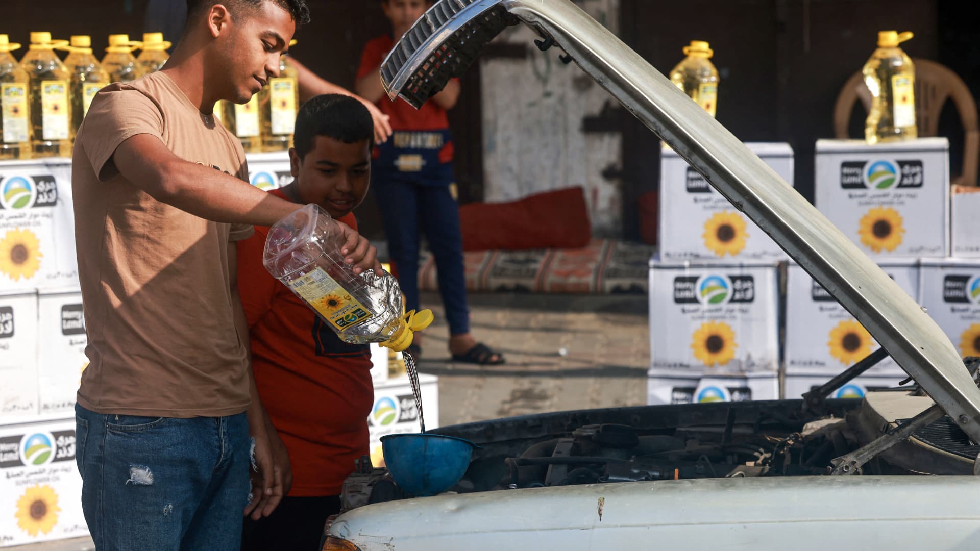 A Palestinian man pours cooking oil into a car in Rafah in the southern Gaza Strip, on November 8, 2023, amid the ongoing battles between Israel and the militant group Hamas. 