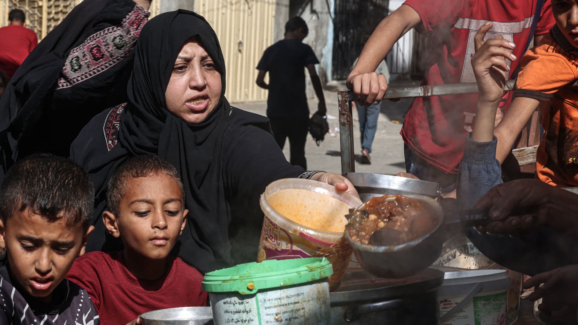 Palestinians queue to receive a portion of food at a make-shift charity kitchen in Rafah in the southern Gaza Strip, on November 8, 2023, amid the ongoing battles between Israel and the militant group Hamas. 