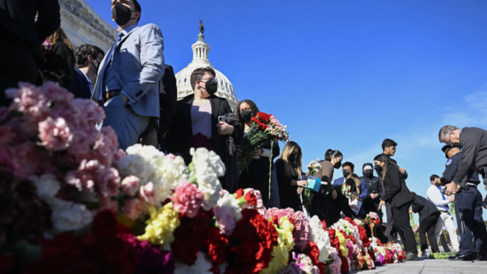 Congressional staff lay down roses and carnations on the stairs in front of the congress building for those who lost their lives in Gaza due to Israeli attacks as they unfurl banner demanding a ceasefire on November 08, 2023 in Washington D.C, United States. 