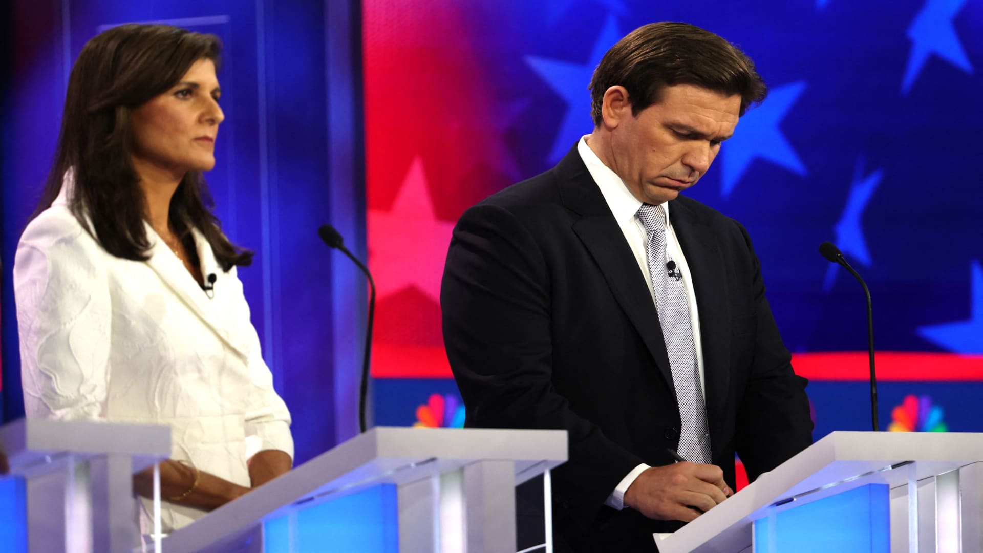 Florida Governor Ron DeSantis takes notes as former South Carolina Governor Nikki Haley looks on at the third Republican candidates' U.S. presidential debate of the 2024 U.S. presidential campaign hosted by NBC News at the Adrienne Arsht Center for the Performing Arts in Miami, Florida, U.S., November 8, 2023. 