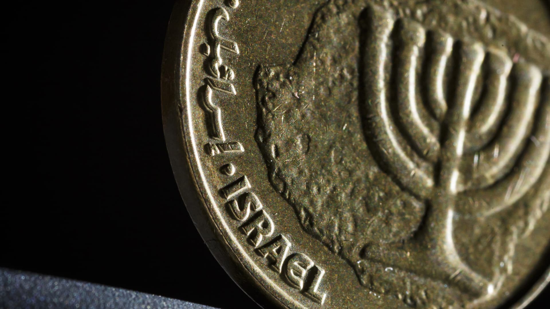 BERLIN, GERMANY - JANUARY 06: The lettering Israel is seen on a 10 agorot coin stands on a table on January 06, 2015 in Berlin, Germany. The currency of the State of Israel is called New Israeli Shekel (NIS). The shekel consists of 100 agorot. (Photo Illustration by Thomas Trutschel/Photothek via Getty Images)