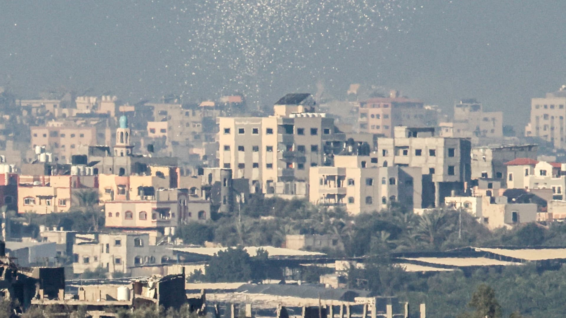 A picture taken from the border between Israel and Gaza shows leaflets being dropped by the Israeli army over Gaza City.