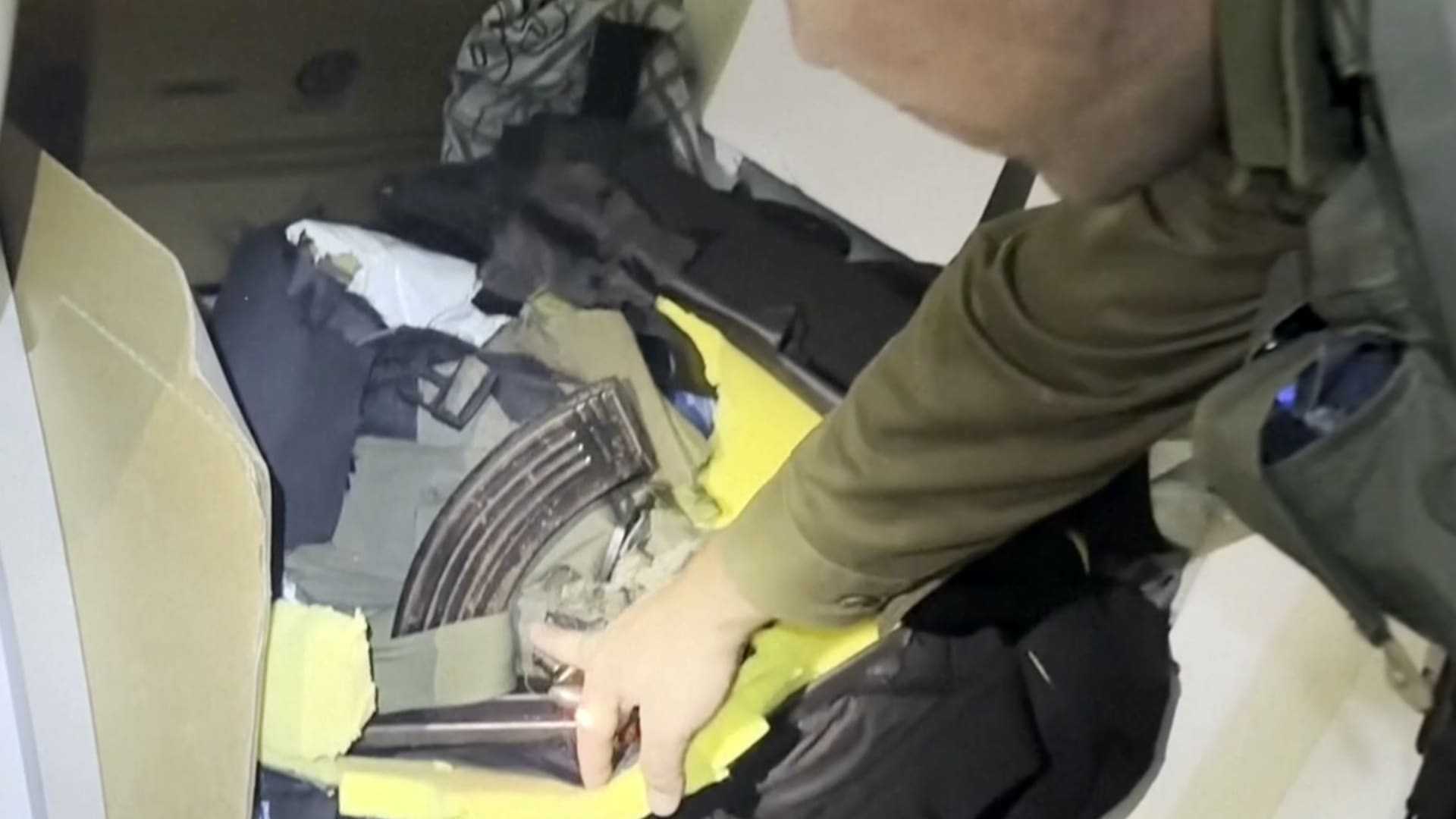 In this image taken from a video released by the Israeli Defense Forces, Wednesday, Nov. 15, 2023, Lt. Col. Jonathan Conricus, an Israeli military spokesman, points to a cache weapons the IDF says were found in an MRI center at the al-Shifa hospital in Gaza City. 