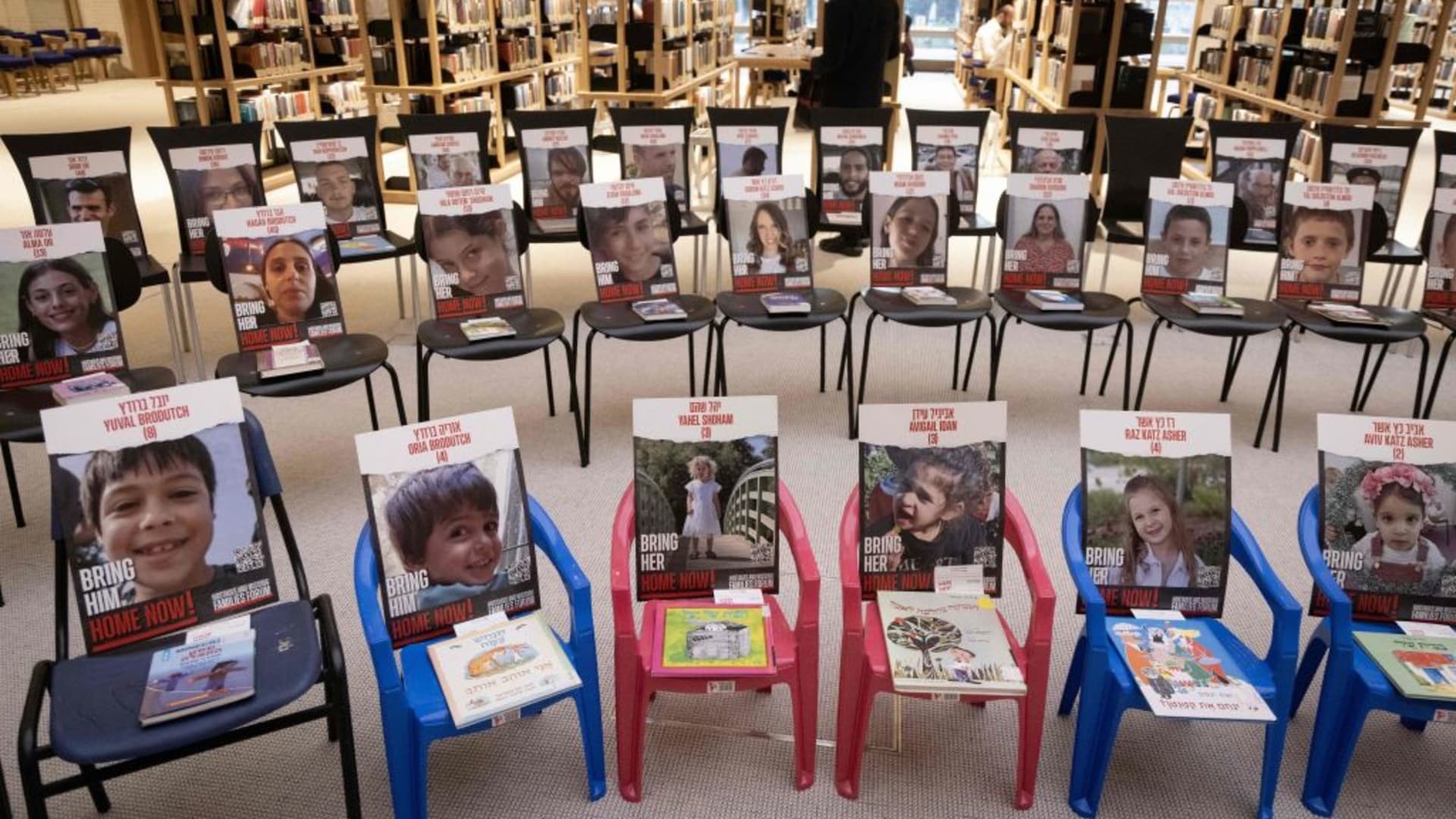 A picture taken on November 21, 2023 at the new building of the National Library of Israel in Jerusalem, shows an installation consisting of chairs with books and portraits of Israeli hostages taken by Palestinian Hamas militants during the October 7 attack.