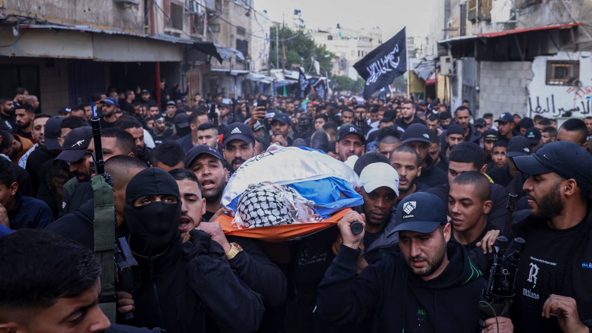 Palestinian mourners carry the body of one of the six Palestinians killed in clashes with Israeli forces during their funeral in the northern occupied West Bank city of Tulkarem on November 22, 2023.