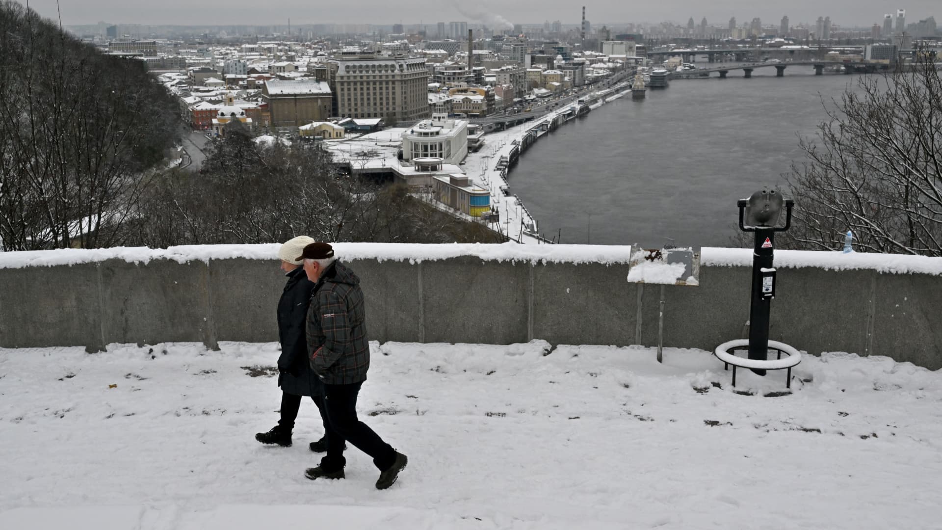 A couple walks in a snow covered park in Kyiv on November 22, 2023.