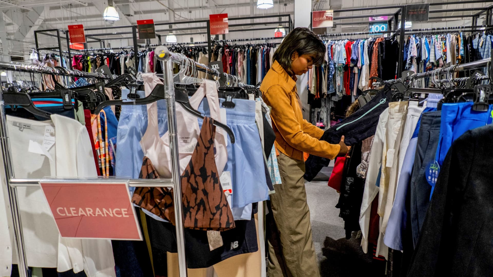 A person picks out clothing in a store as retailers compete to attract shoppers and try to maintain margins on Black Friday, one of the busiest shopping days of the year, at Woodbury Common Premium Outlets in Central Valley, New York, U.S. November 24, 2023. 