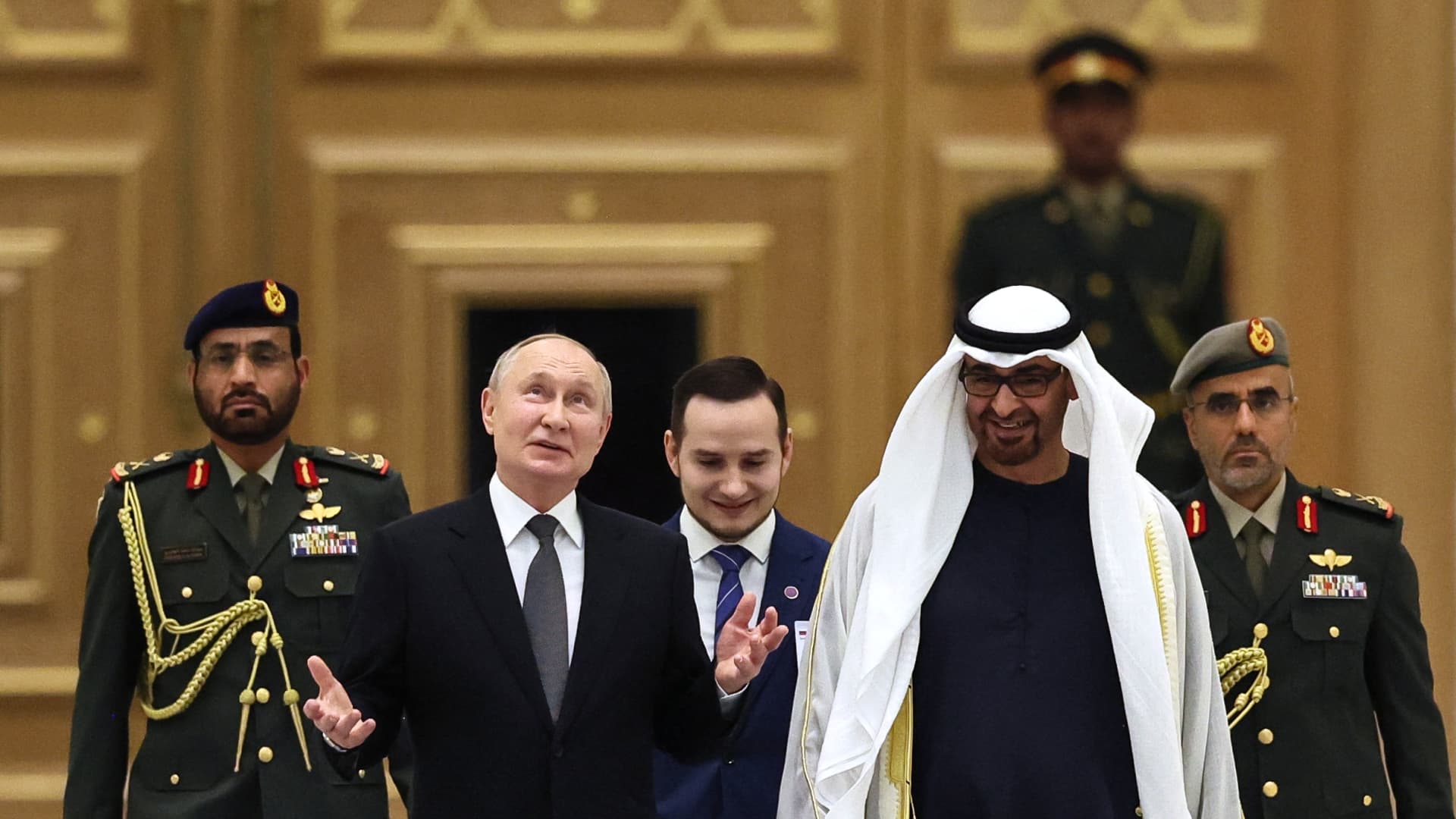 This pool photograph distributed by Russian state agency Sputnik shows Russia's President Vladimir Putin and President of the United Arab Emirates Sheikh Mohamed bin Zayed Al Nahyan attending a welcoming ceremony ahead of their talks in Abu Dhabi on December 6, 2023.