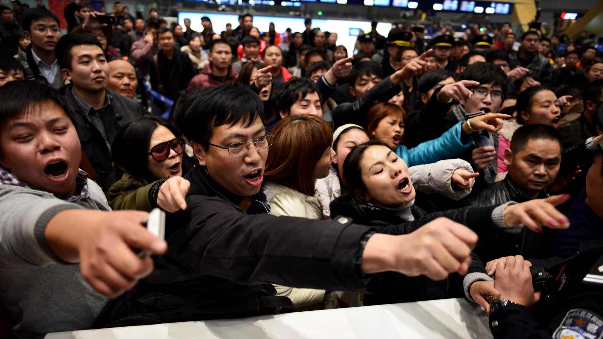 Stranded passengers crowd an airline counter at Changshui International Airport in Kunming, China on Jan. 4, 2013.