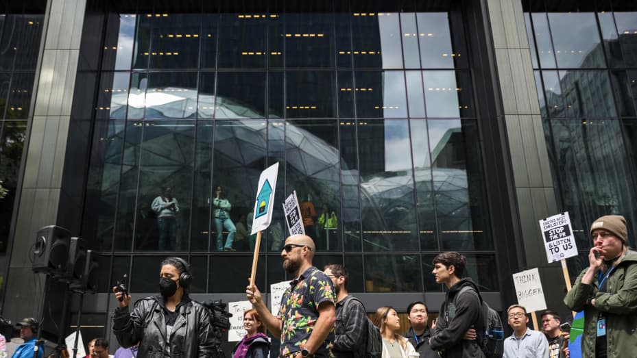 The Amazon Spheres are reflected in windows as Amazon employees and supporters gather during a walk-out protest against recent layoffs, a return-to-office mandate, and the company's environmental impact, outside Amazon headquarters in Seattle, Washington, on May 31, 2023.