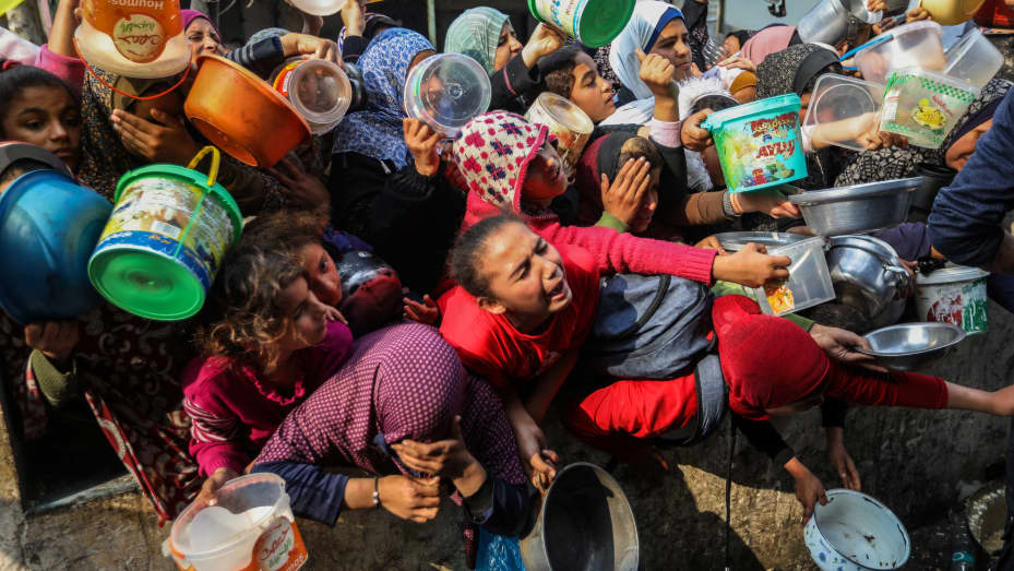 RAFAH, GAZA - 28 DE DICIEMBRE: Los ciudadanos hacen cola para recibir comida cocinada en ollas grandes y distribuida gratuitamente durante tiempos de guerra el 28 de diciembre de 2023 en Rafah, Gaza.  Más de 20.000 palestinos en Gaza han muerto desde los ataques de Hamás en Israel el 7 de octubre, según el Ministerio de Salud de Gaza dirigido por Hamás.  Mientras que el 93 por ciento de los 2,3 millones de habitantes de Gaza padecen "inseguridad alimentaria aguda", según el Programa Mundial de Alimentos.  (Foto de Ahmad Hasaballah/Getty Images)