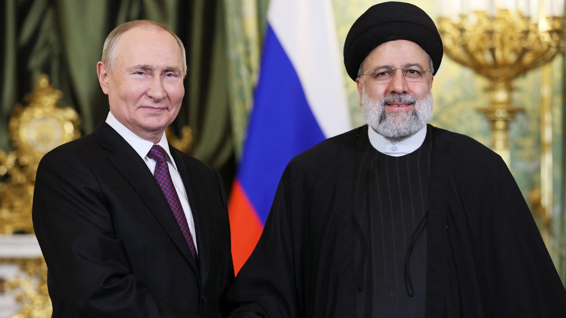 In this pool photograph distributed by Russian news agency Sputnik on December 7, 2023, Russia's President Vladimir Putin (L) shakes hands with Iran's President Ebrahim Raisi during their meeting in the Kremlin in Moscow.