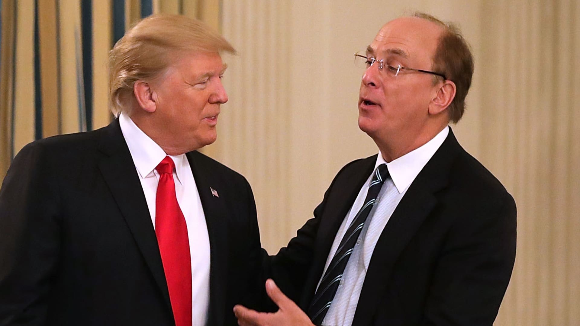 File: President Donald Trump (C) greets BlackRock CEO Larry Fink at the beginning of a policy forum in the State Dining Room at the White House February 3, 2017 in Washington, DC.