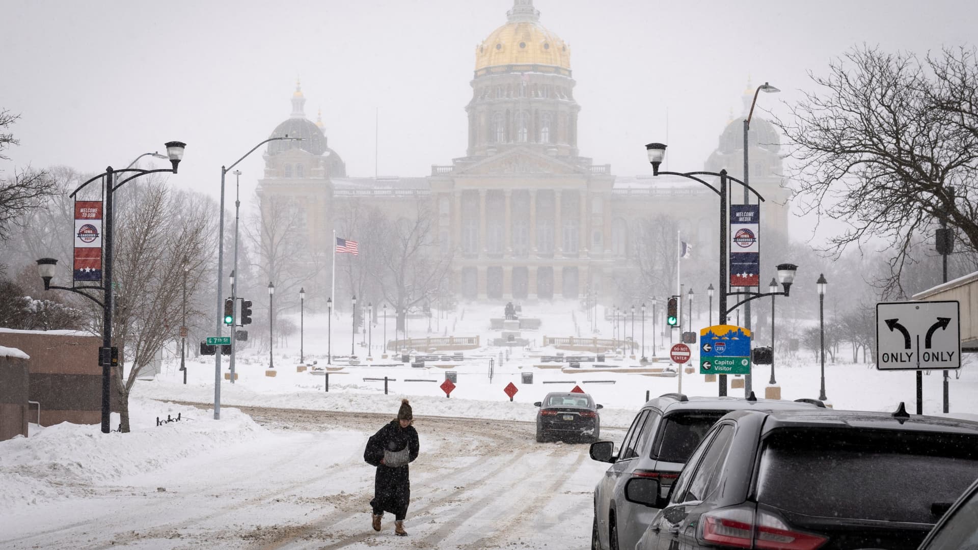 A woman walks in the street in front of Iowa state capitol after a blizzard left several inches of snow, in downtown Des Moines, Iowa, U.S., January 13, 2024. 