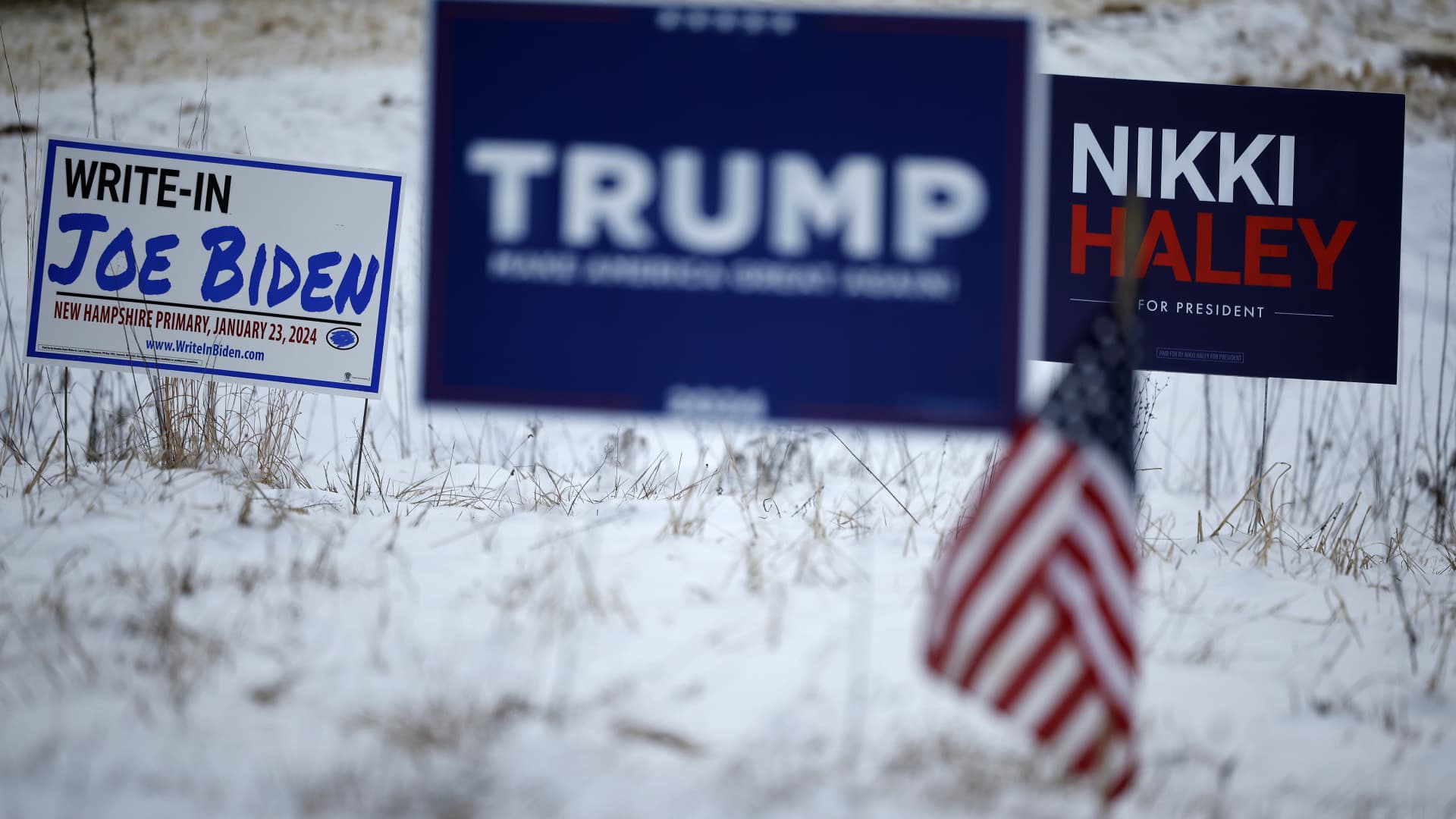 Campaign signs for Republican presidential candidates former President Donald Trump and former United Nations Ambassador Nikki Haley stand next to a sign asking voters to write in President Joe Biden in the Jan. 23 primary election, in Loudon, New Hampshire, on Jan. 19, 2024.