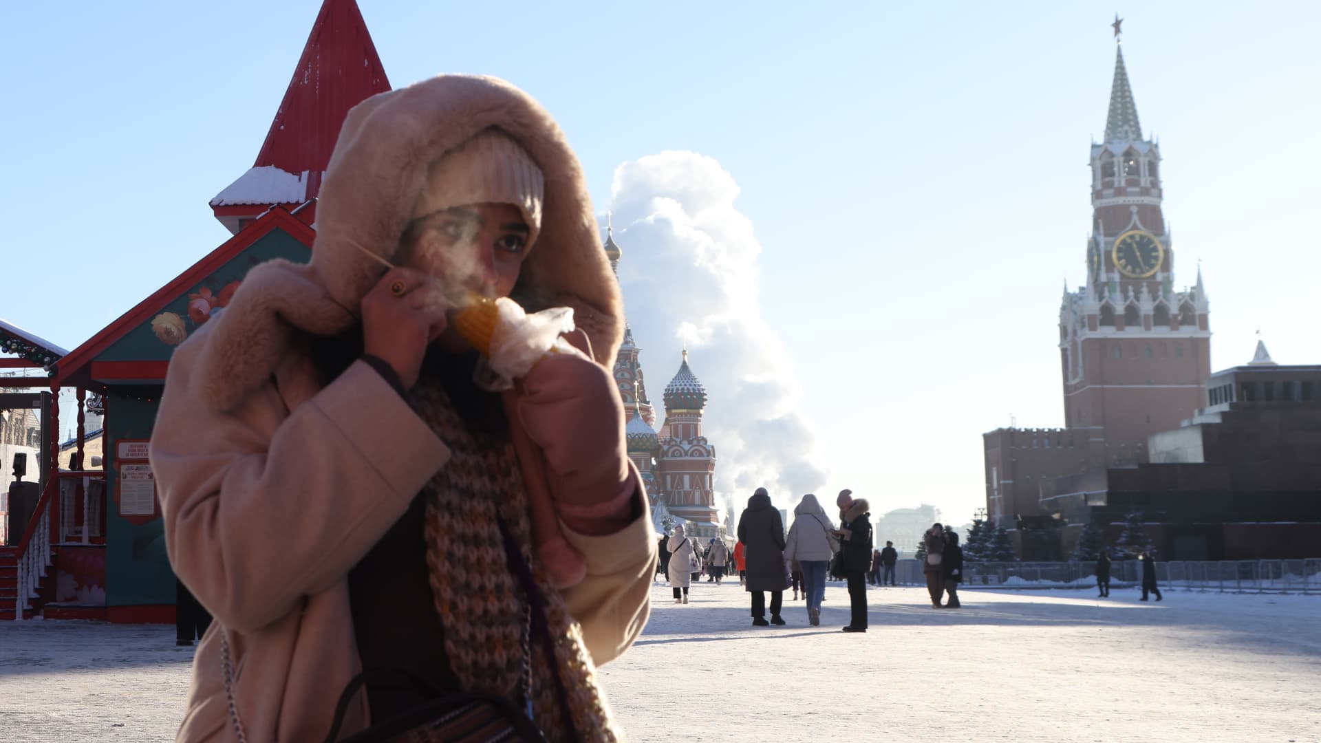 MOSCOW, RUSSIA - JANUARY 8:(RUSSIA OUT) A woman eats hot corn while walking along the Red Square near the Kremlin, as air temperatures dropped to -18 degrees Celcius, January,8 2024, in Moscow, Russia. Since the beginning of the year, abnormally cold weather has settled in Moscow region, causing problems with heating in apartments. (Photo by Contributor/Getty Images)